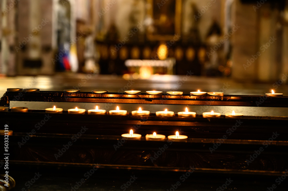 Lampion candles glowing in a dark church