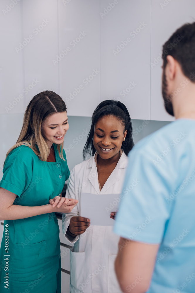 Multiracial team of doctors discussing a patients condition while working in a hospital Multiracial team of doctors discussing a patients condition while working in a hospital