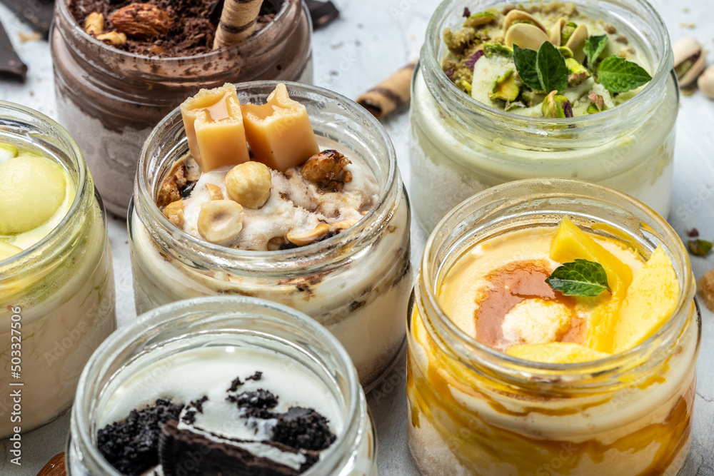 Large collection of Ice cream, delicious gelati with fresh pistachio, chocolate, caramel, melon, mango, chocolate chip sandwich cookies with aromatic vanilla pod on white