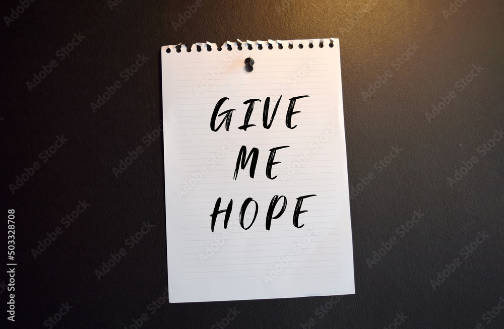 Paper note with GIVE ME HOPE. written on black slate board Paper note with GIVE ME HOPE. written on black slate board
