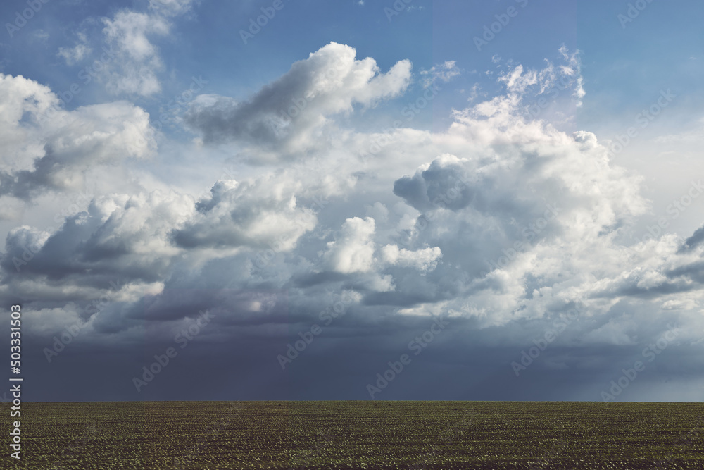 Dark rainy clouds over the field as a background or backdrop