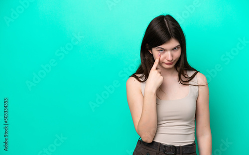 Young Russian woman isolated on green background showing something © luismolinero