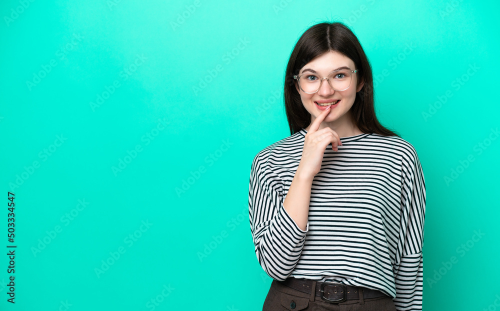 Young Russian woman isolated on green background showing a sign of silence gesture putting finger in mouth Young Russian woman isolated on green background showing a sign of silence gesture putting finger in mouth