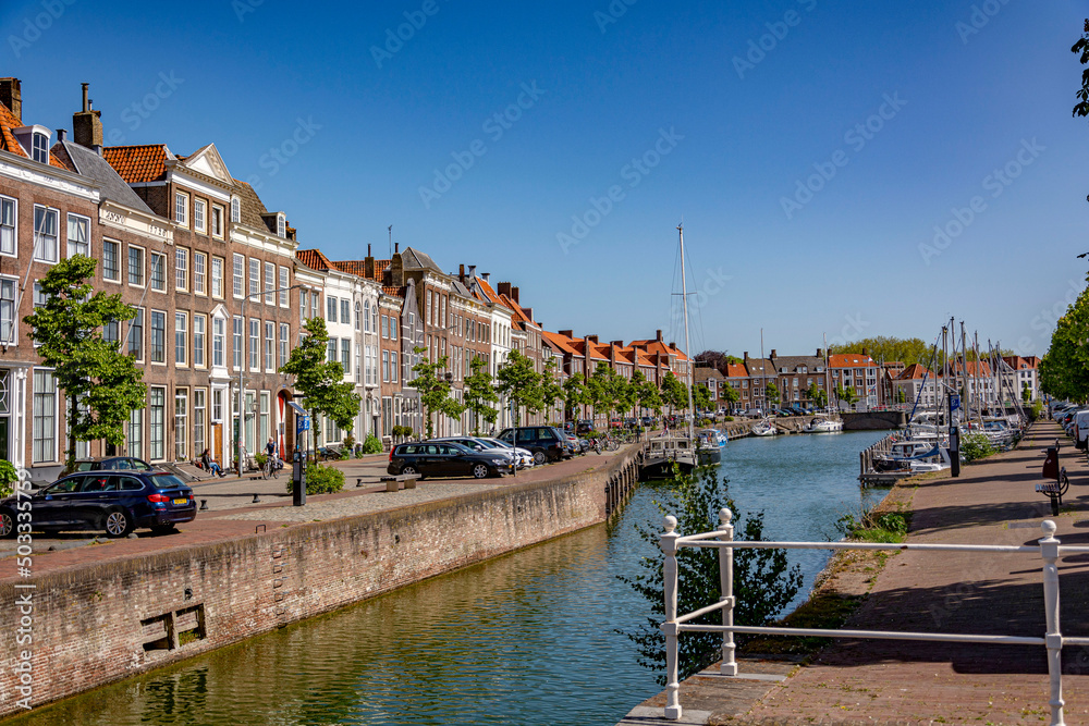 Obraz premium Sunny summer day by the water canal in Middelburg, facing the row of a building facades