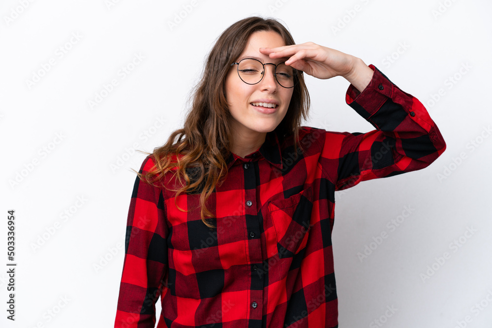 Young caucasian woman isolated on white background looking far away with hand to look something