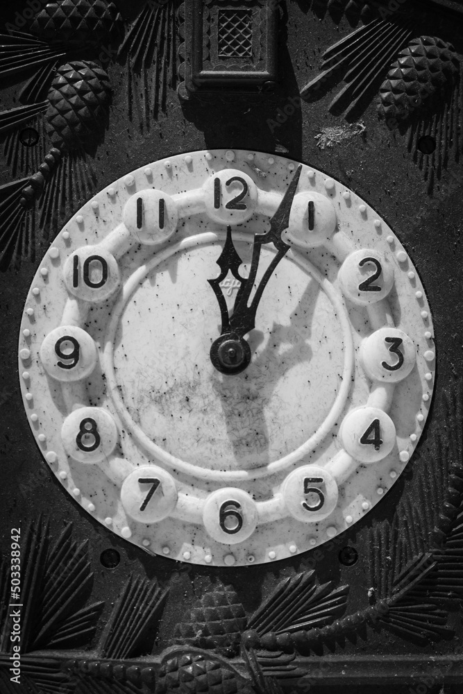 Old clock mechanism, black and white. Retro clock arrows and numbers. Time measure. New year concept. The past epoch. Hour and minute arrows. Dirty ancient clock in dust. Old clock face.