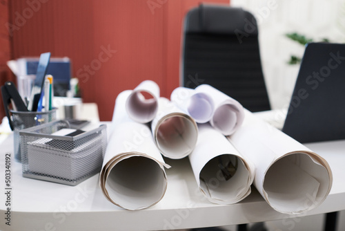 Close-up of blueprints of construction projects on table of architect at office