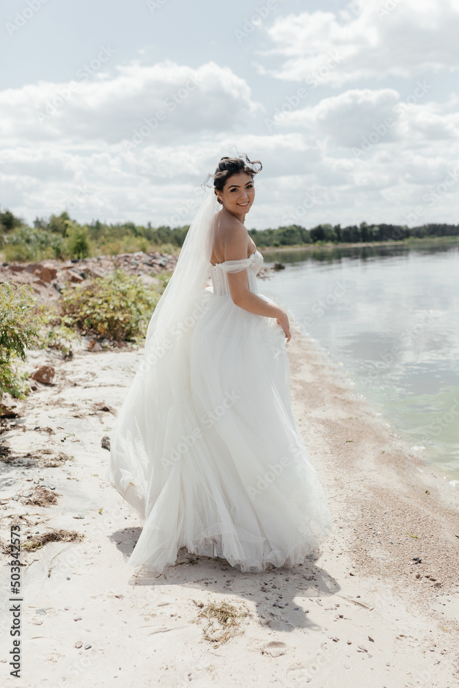 The bride runs along the river