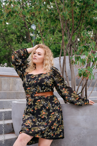 model plus size blonde in trendy retro dress curly blonde in park city walk portrait banner advertising clothes