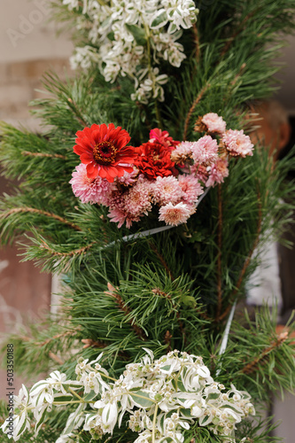 Pink flowers and green needles of a Christmas tree. Festive decor