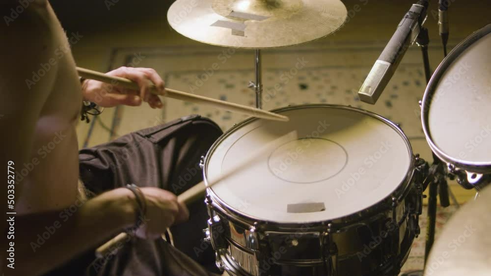 Young male drummer playing drums at music studio while rehearsing alone. Musician performing on percussion instruments. High angle shot. Music, musical instruments concept Young male drummer playing drums at music studio while rehearsing alone. Musician performing on percussion instruments. High angle shot. Music, musical instruments concept