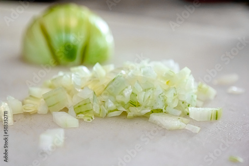 Composition with fresh onions on white table. chopped onions on cutting board  top view. Sliced onions on a cutting board to prepare meals