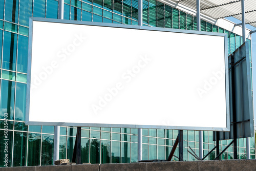Advertising billboard mock-up in front of modern office building with glass facade