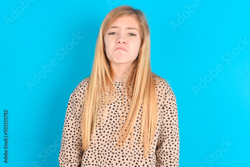 Fotografie, Obraz Displeased upset little caucasian kid girl wearing animal print sweater over blu