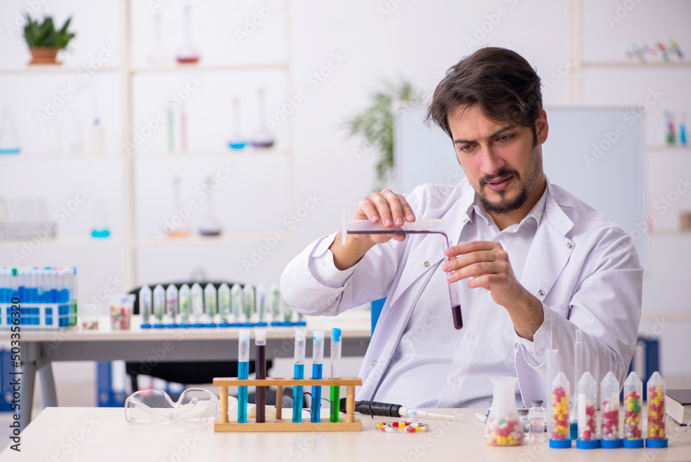 Young male chemist in drugs synthesis concept Young male chemist in drugs synthesis concept