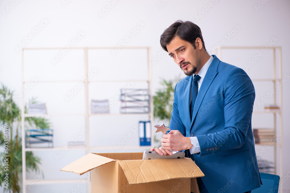 Young male employee in business relocation concept Young male employee in business relocation concept