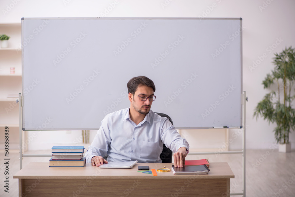 Young male teacher in front of whiteboard Young male teacher in front of whiteboard