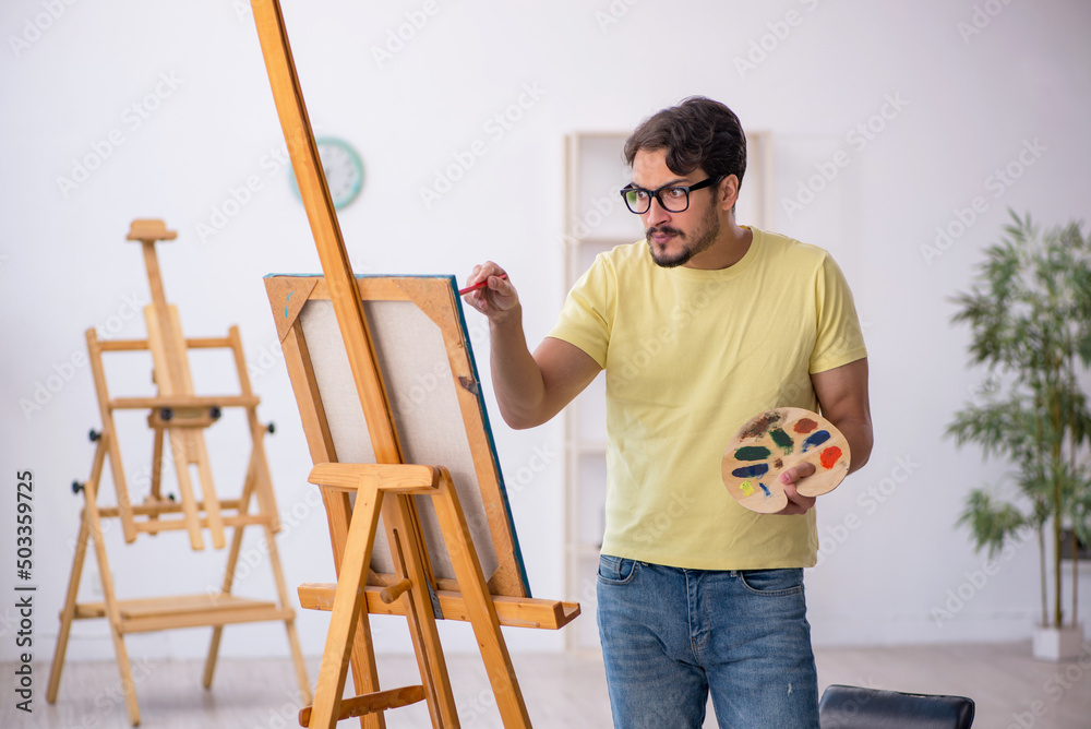 Young man enjoying painting at home