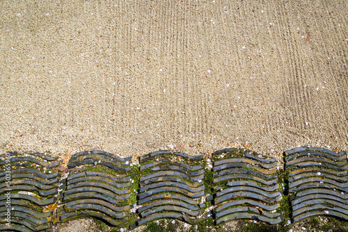 Dry landscape （Karesansui ）with scattered cherry petals.Roof tiles buried in the ground as partitions photo