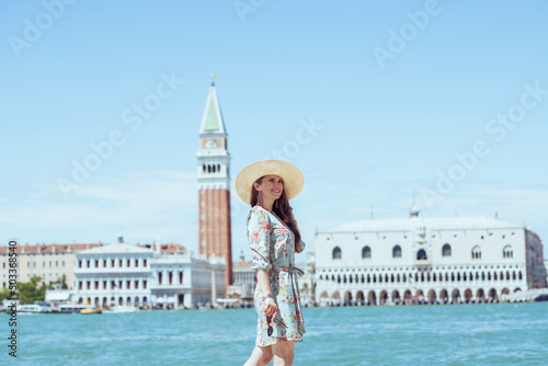 smiling elegant woman in floral dress having walking tour © Alliance