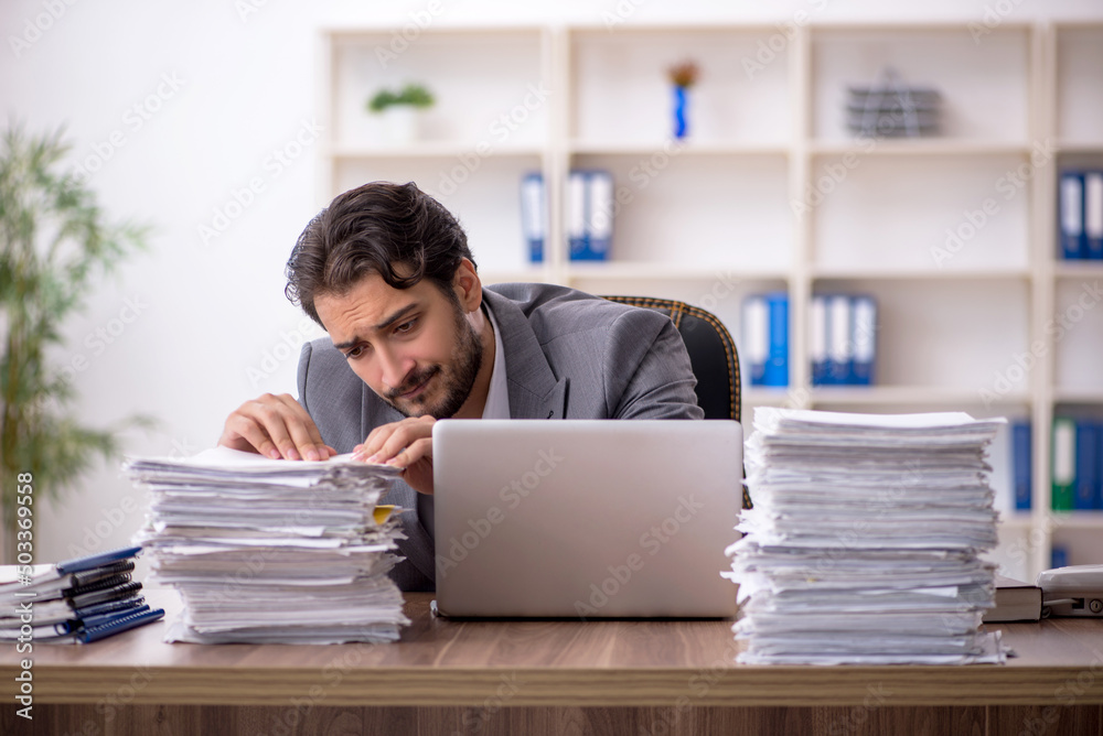 Young male employee and too much work in the office