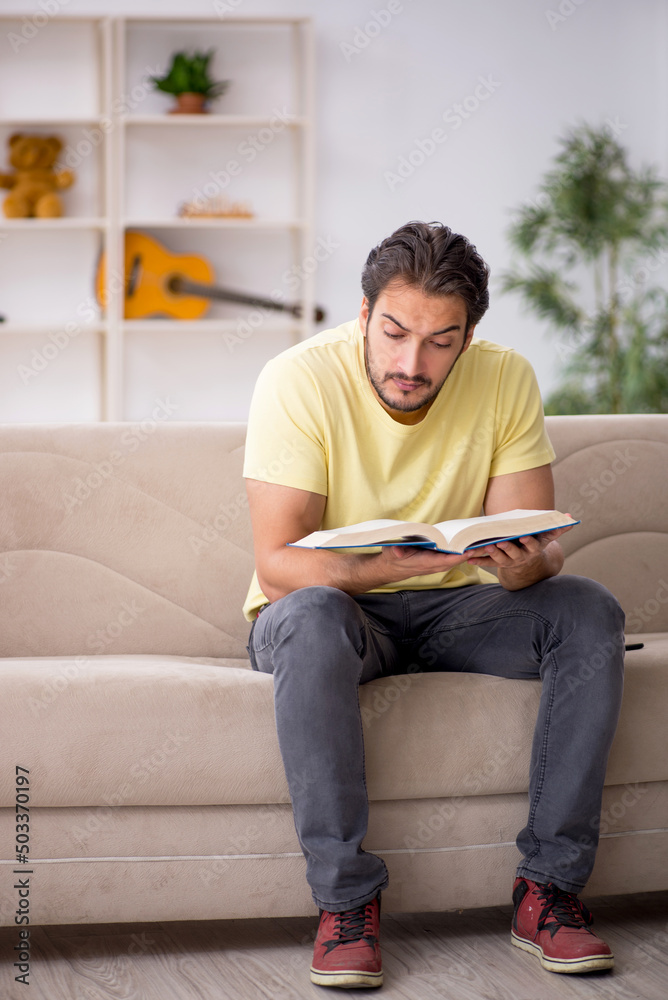 Young man reading book at home during pandemic Young man reading book at home during pandemic