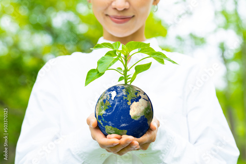 Asian woman holding a flowerpot with a pattern of the earth. Environment concept. Sustainable development goals. SDGs.