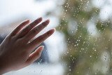 雨粒の窓に置かれた女性の手　Female hands