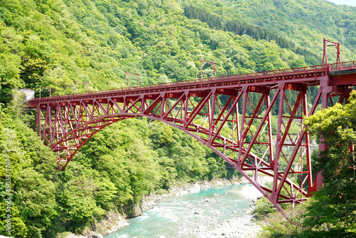 富山県黒部市宇奈月の黒部峡谷鉄道にかかる赤い鉄橋の写真・観光名所・絶景