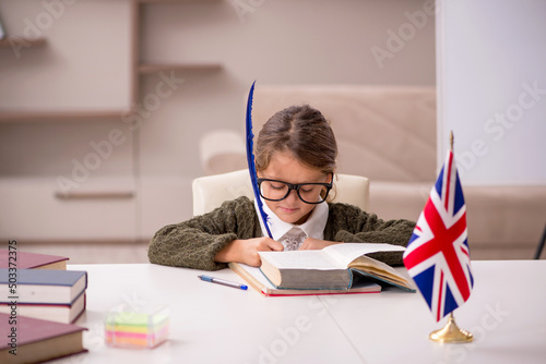 Young little girl studying english language at home