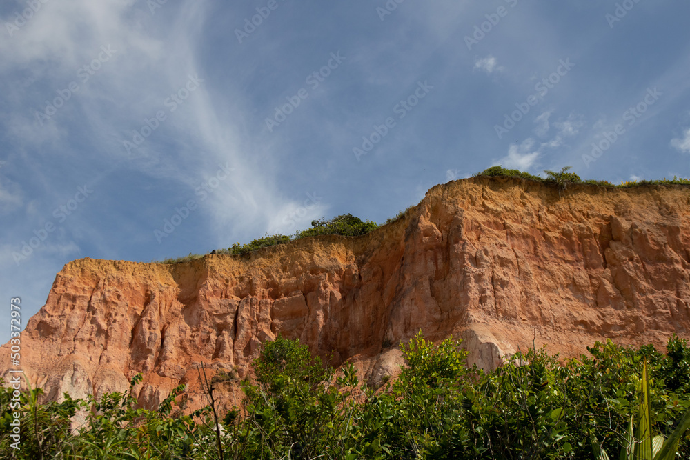 Cliff in Trancoso, Bahia, Brazil. Typical rocks common on coast. Cliff and trees.  