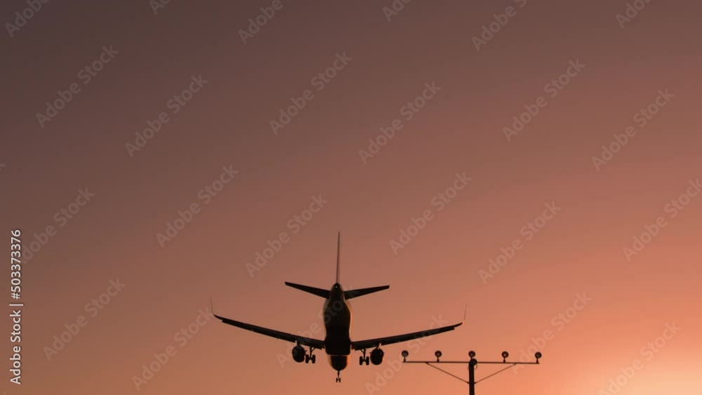 Bottom view airplane with tourists landing in airport at night. Tourism cinematic sunset at airport, 6K travel footage Scenic pink sunset sky on summer evening. Holiday vacation tourism concept video Bottom view airplane with tourists landing in airport at night. Tourism cinematic sunset at airport, 6K travel footage Scenic pink sunset sky on summer evening. Holiday vacation tourism concept video