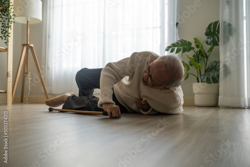 Asian senior male falling on the ground while walk with walker at home.  © Kawee