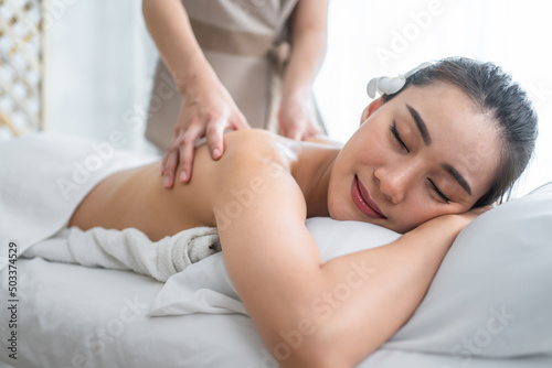 Asian young woman feeling happy and relax during back massage with oil. 