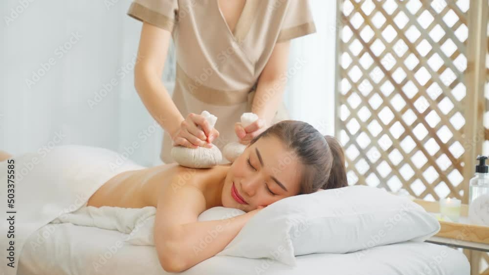 Asian beautiful woman enjoy thai hot compress massage with herbal bags. Asian beautiful woman enjoy thai hot compress massage with herbal bags.