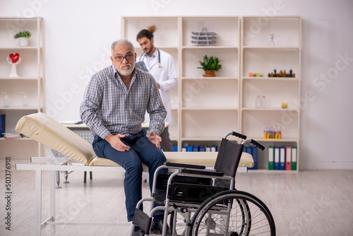 Old man in wheelchair visiting young male doctor