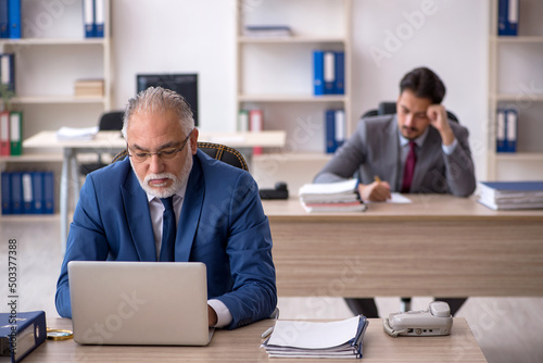 Two male colleagues working in the office © Elnur