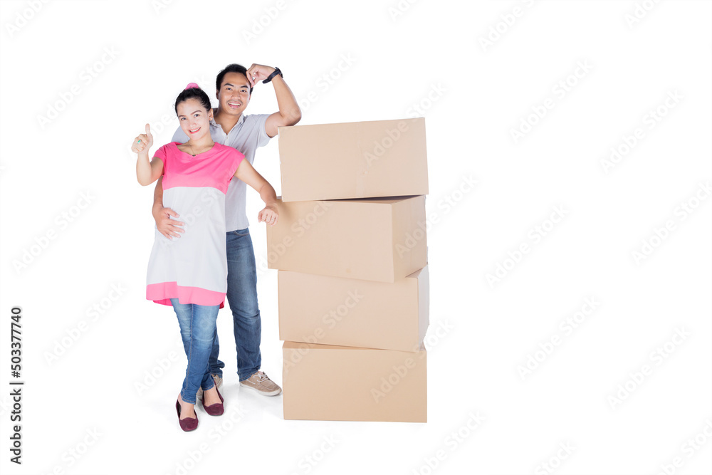 Young couple showing thumb up near cardboard box Young couple showing thumb up near cardboard box