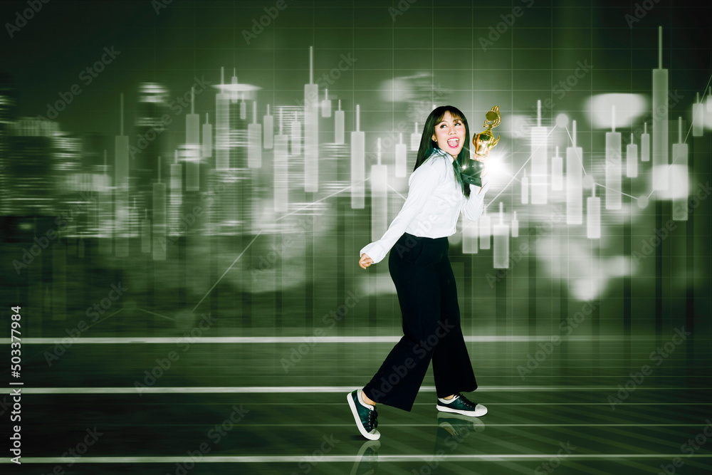 Businesswoman holds trophy near candlestick chart Businesswoman holds trophy near candlestick chart