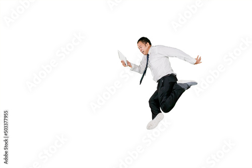 Businessman using tablet while jumping on studio