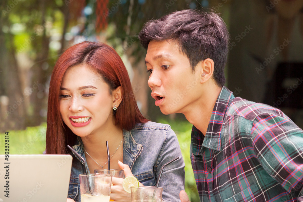 Close up of young couple using laptop in cafe Close up of young couple using laptop in cafe