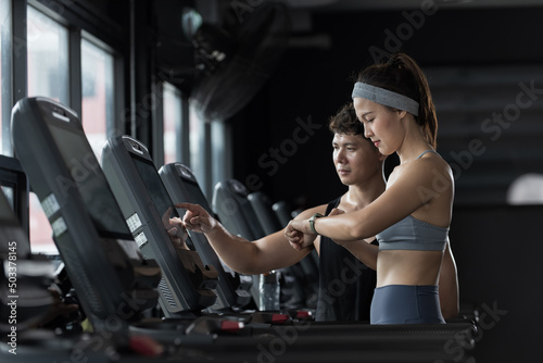 woman in gym. woman exercising with trainer in gym. Woman working out in gym.