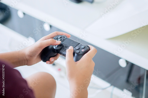 Preteen boy using a joystick while playing games