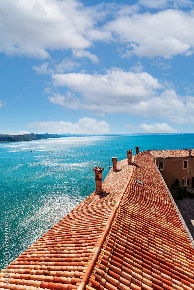 View of the coast from Duino Castle on a cliff above the Gulf of Trieste (Adriatic Sea), Italy. Medieval tiled roof of the Duino fortress.