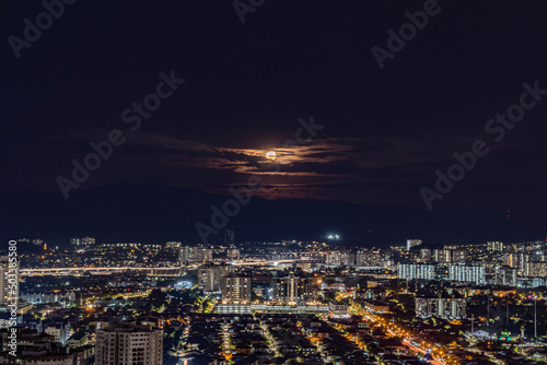 Full moon rising over urban city light