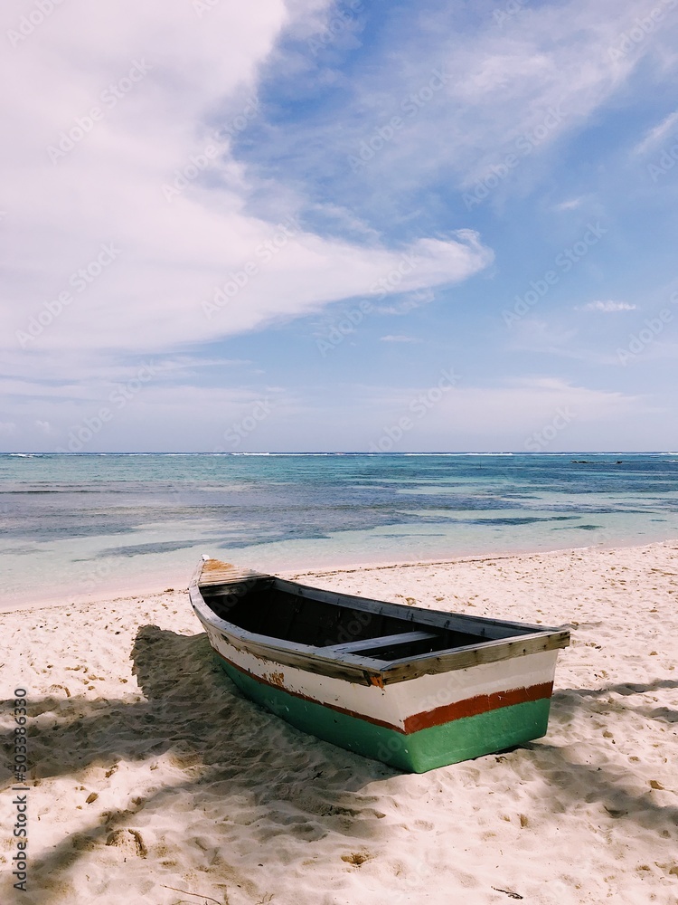 Old wooden boat on the beach with white sand and calm clean ocean view