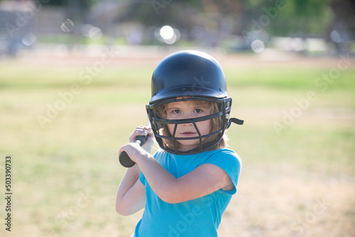 Little child baseball player focused ready to bat. Sporty kid players in helmet and baseball bat in action. © Volodymyr