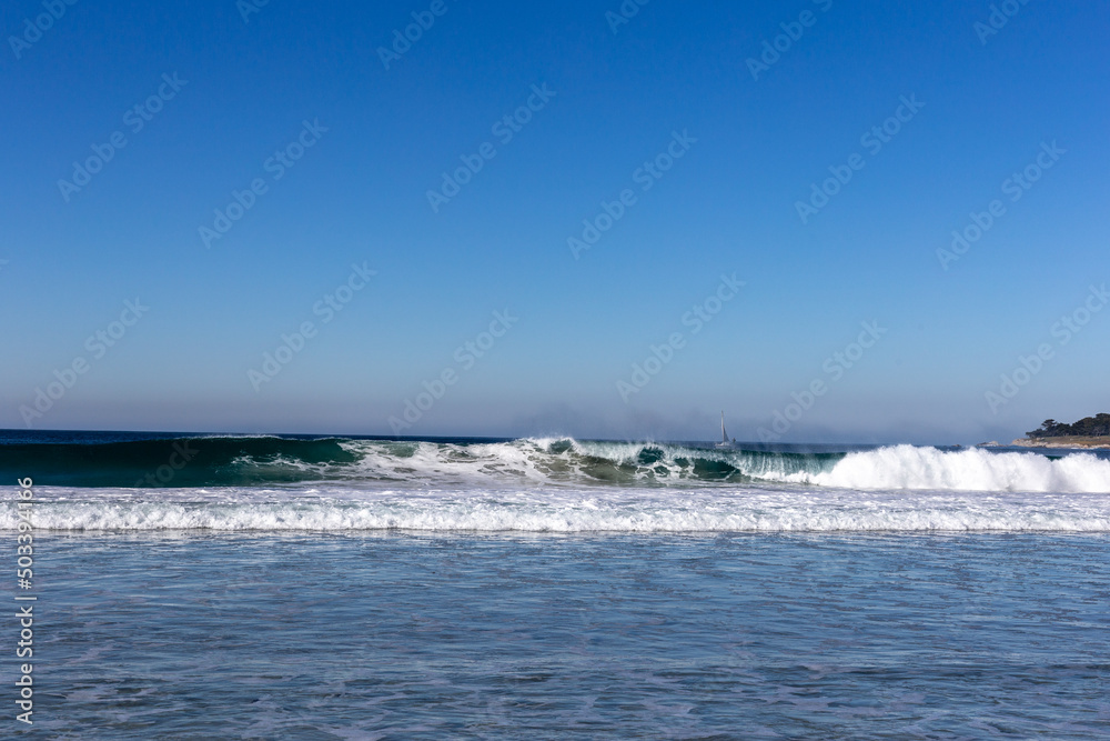 A view on ocean with white waves and blue sky