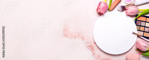 Composition with blank card, decorative cosmetics and tulips on light color background with space for text