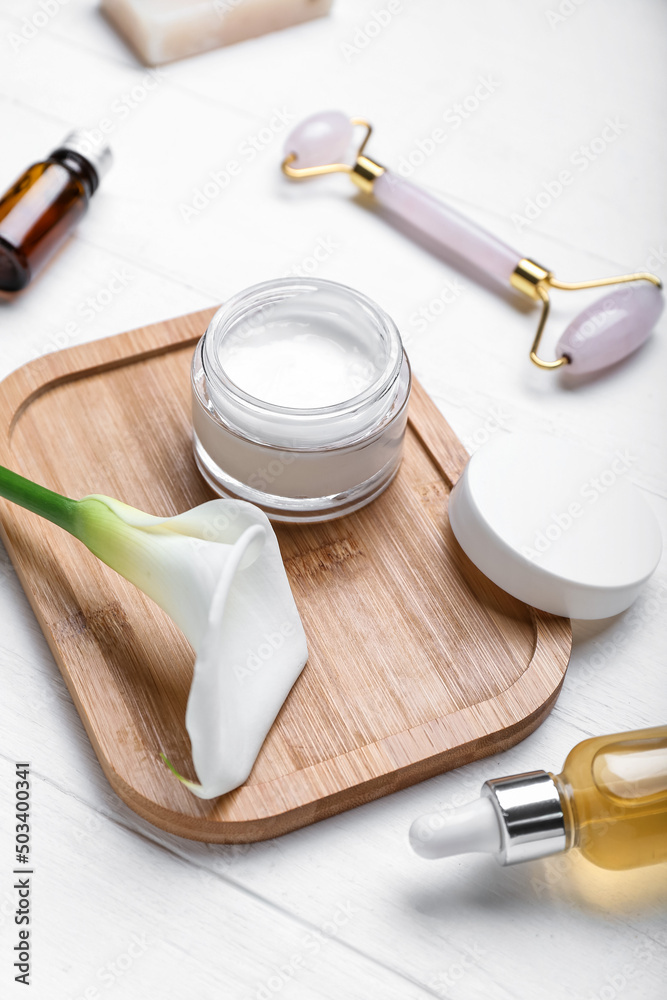 Board with jar of cosmetic product and calla lily on light wooden background, closeup Board with jar of cosmetic product and calla lily on light wooden background, closeup